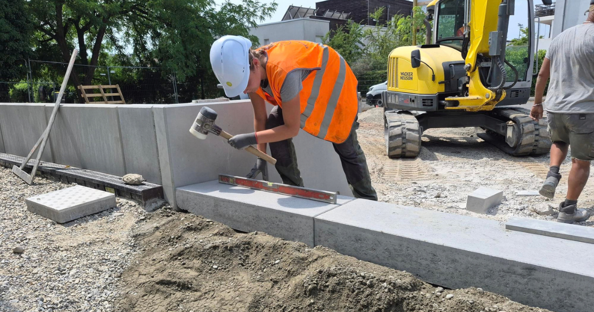 Solène Durr, apprentie paysagiste distinguée parmi les apprentis les plus méritants 2026, ajustant une bordure béton en Alsace